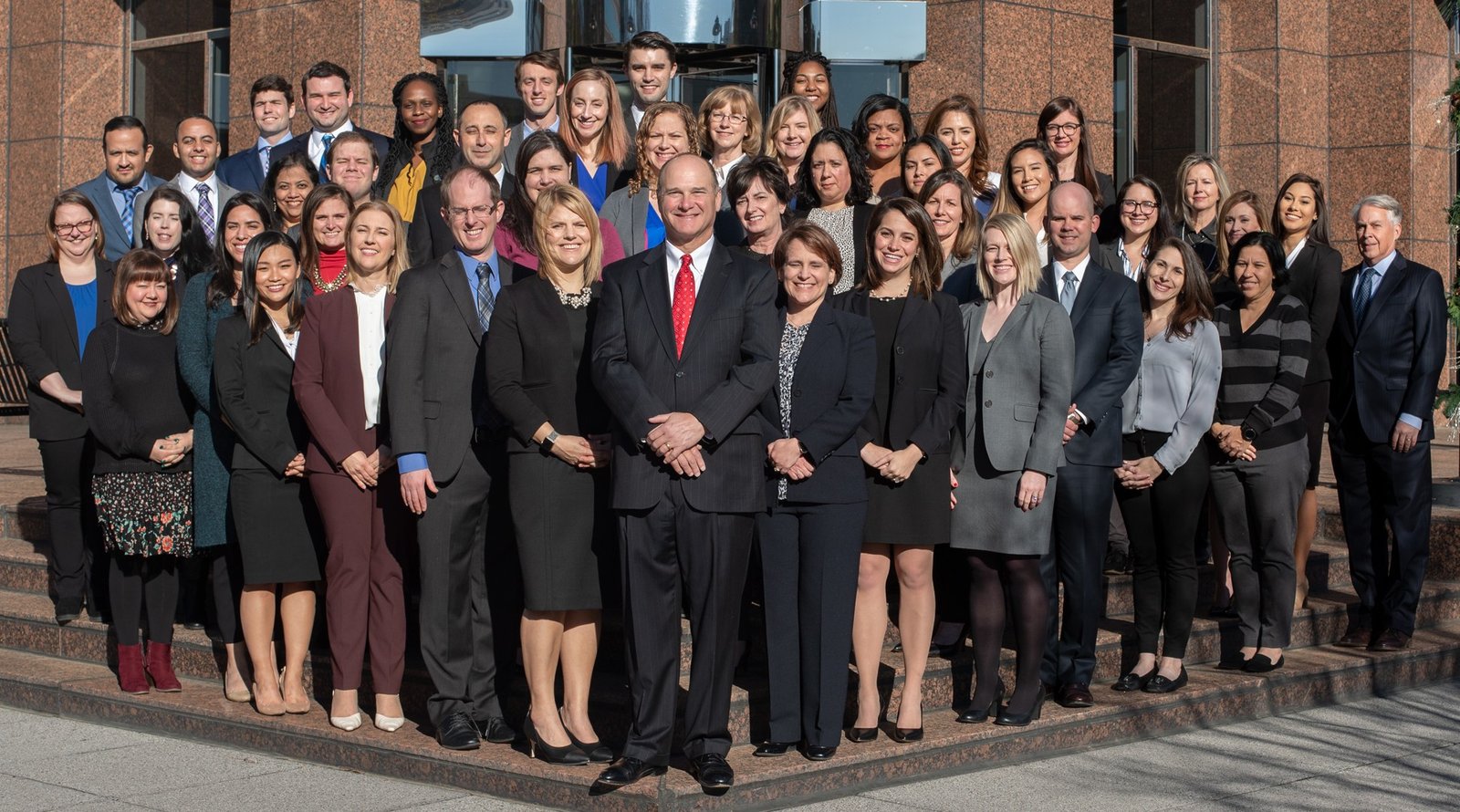The Evan Smith Law Firm team photographed together on the steps outside the office